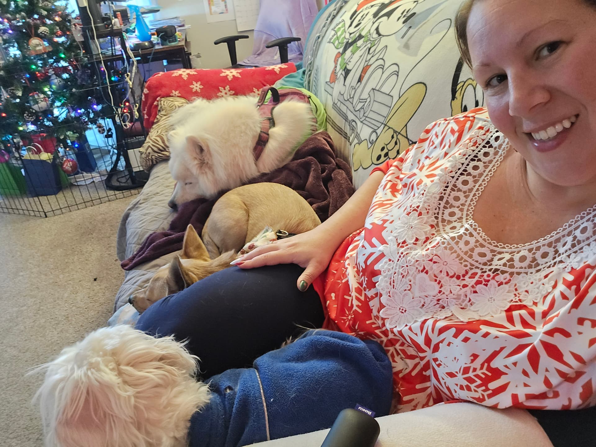 Caitlin relaxing at home with dogs curled up on the couch